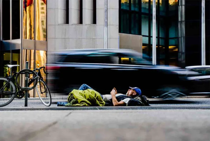 A person enjoying a moment of relaxation on the road's divider, symbolizing financial independence and the ability to take time for oneself amidst a busy world.